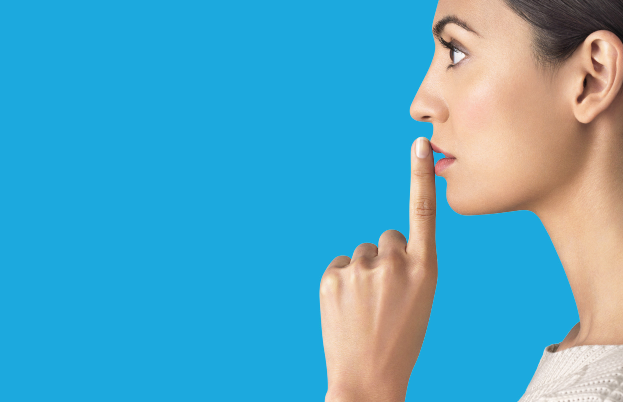 Image of Woman placing finger to mouth to request silence